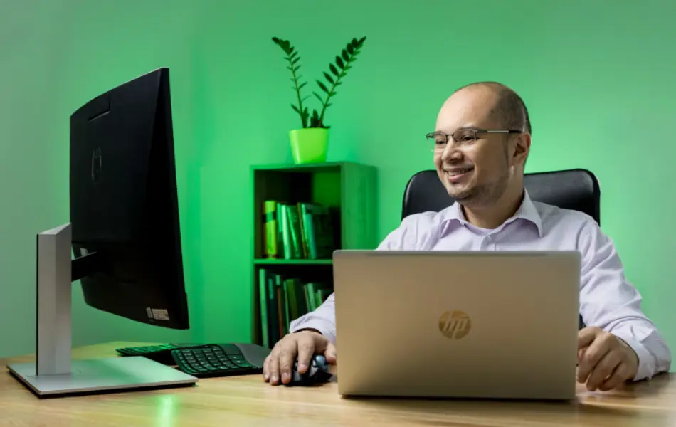 Asesor de atención al cliente trabajando en computador en oficina moderna